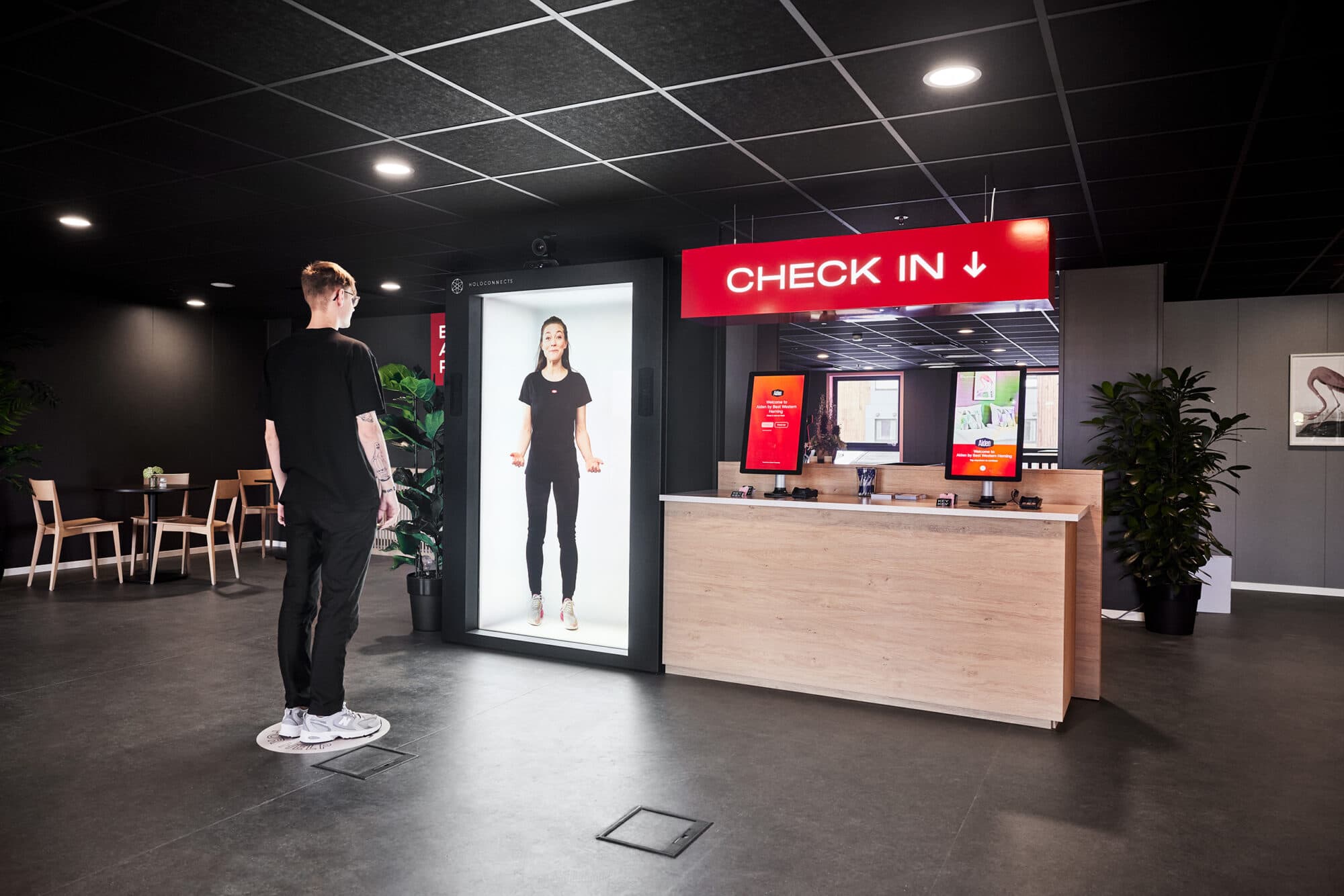 A Holobox hostess welcoming guests in a hotel lobby.