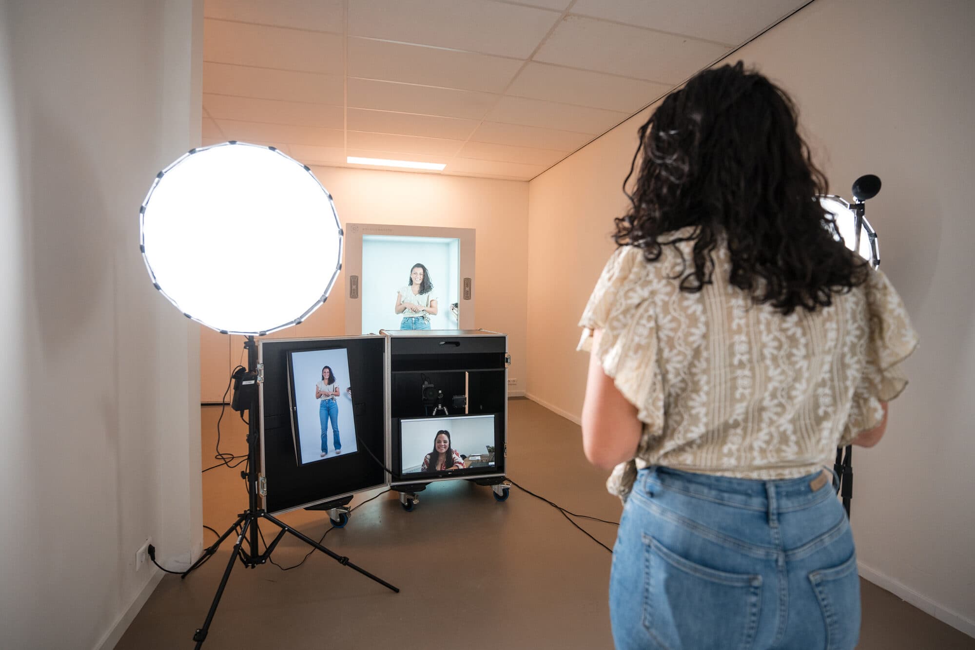 A presenter is recorded with the Holoconnects capture setup; her hologram plays on the Holobox in the background.